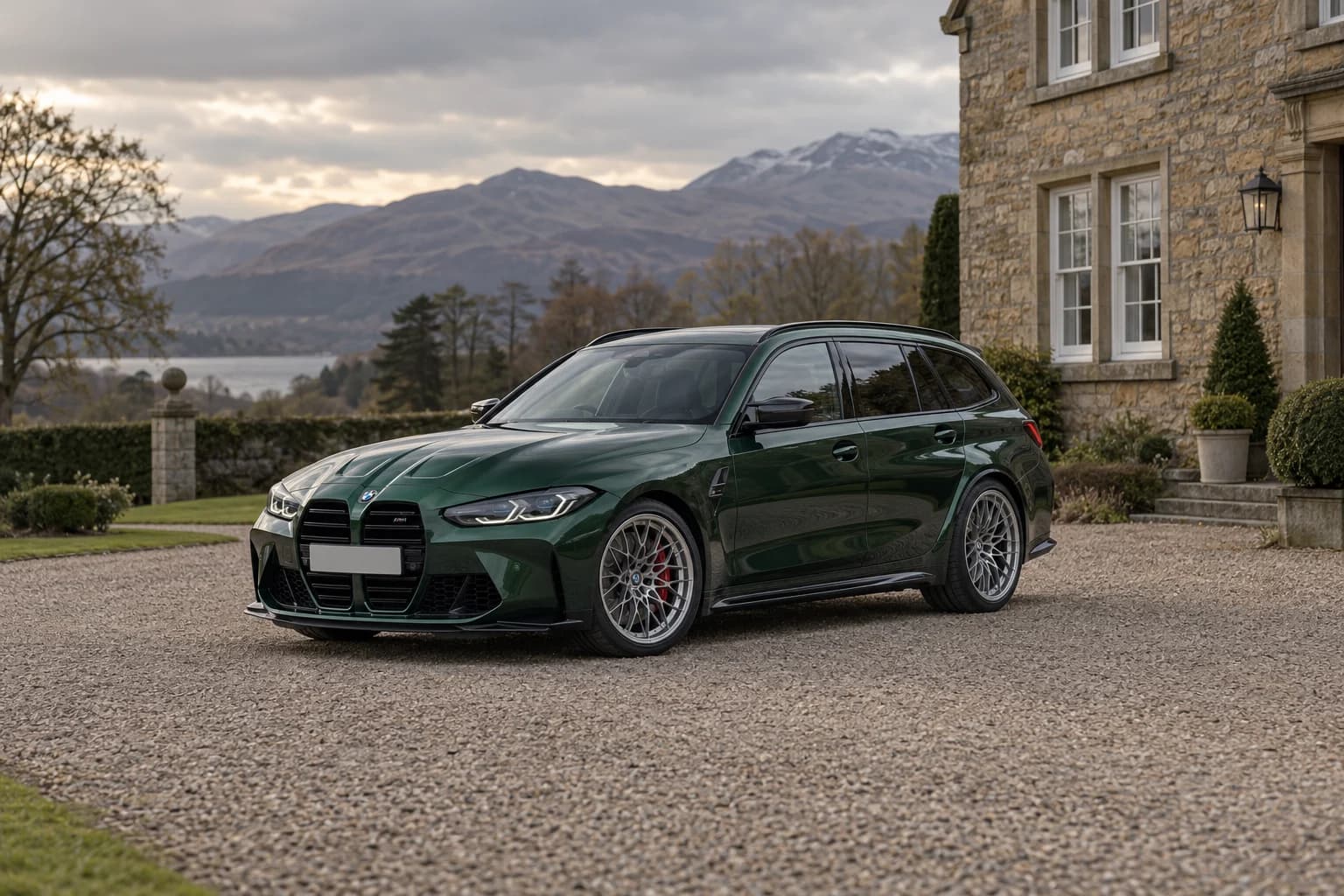 A deep green BMW M3 Competition Touring outside a stone Highland country house
